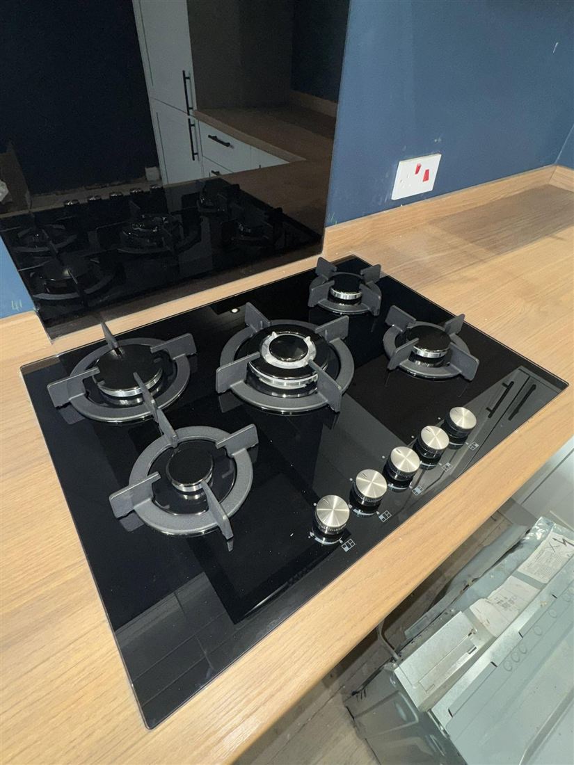 New black glass gas hob in a wooden worktop